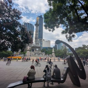 people sitting on benches enjoying Reforma Avenue without cars