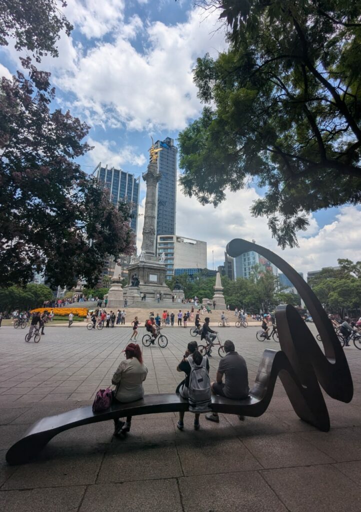people sitting on benches enjoying Reforma Avenue without cars