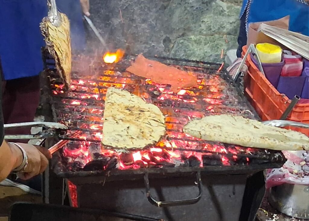 Tlayuda meal being prepared over coals