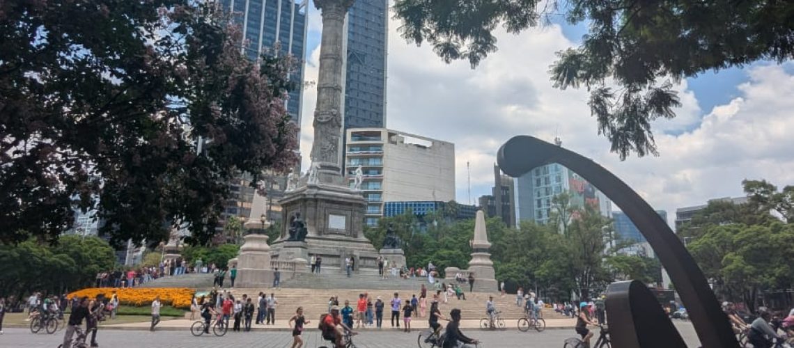 people sitting on benches enjoying Reforma Avenue without cars